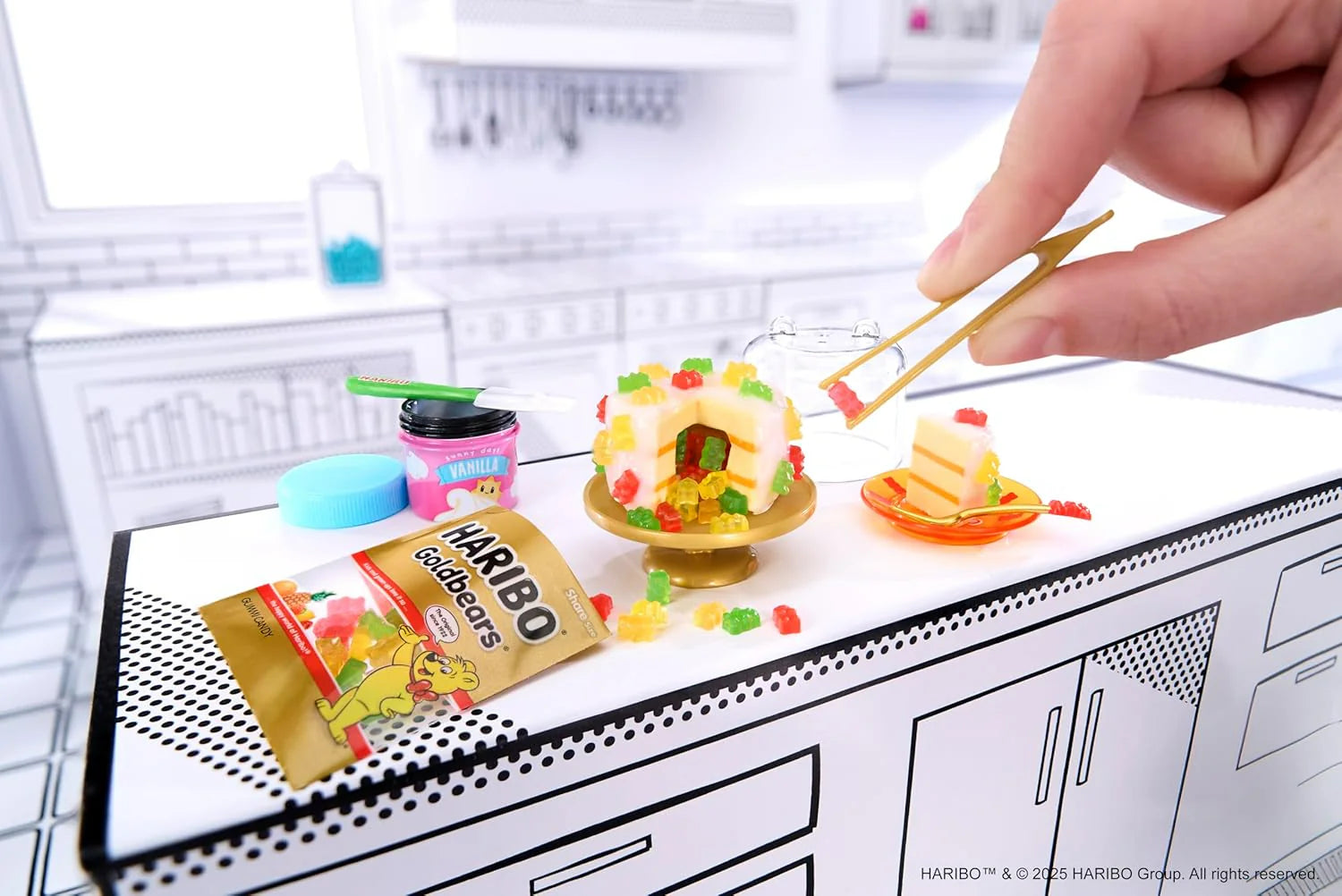Hand assembling mini candy pieces on gold tray from Haribo miniature kit