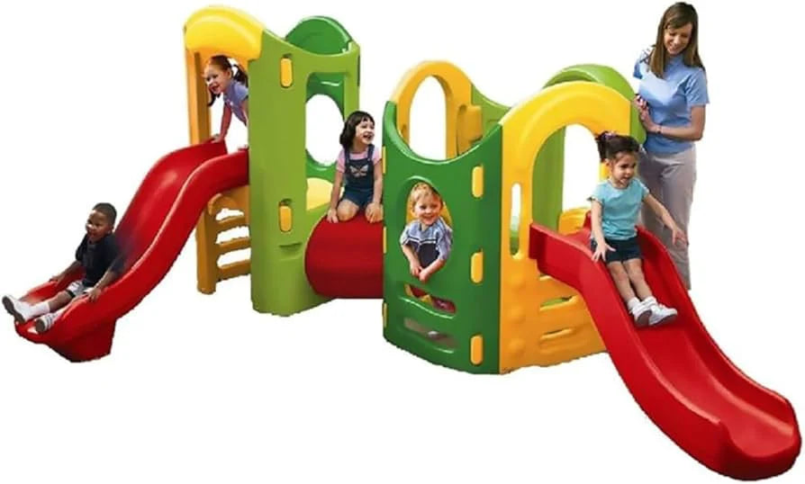 Plastic playground playset with red slide and green-yellow towers, kids playing