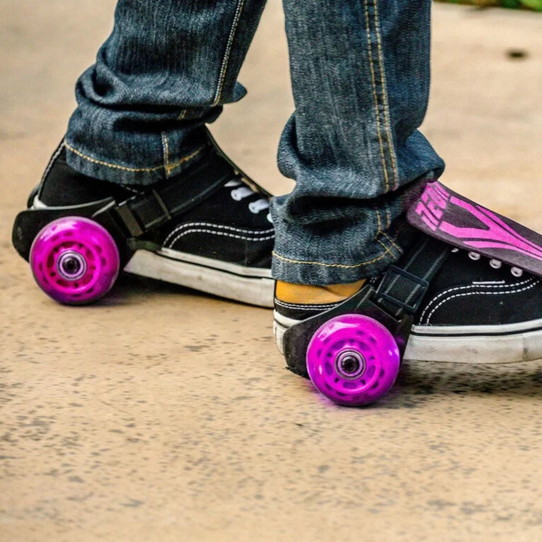 Black roller skates with pink wheels on sneakers, worn view
