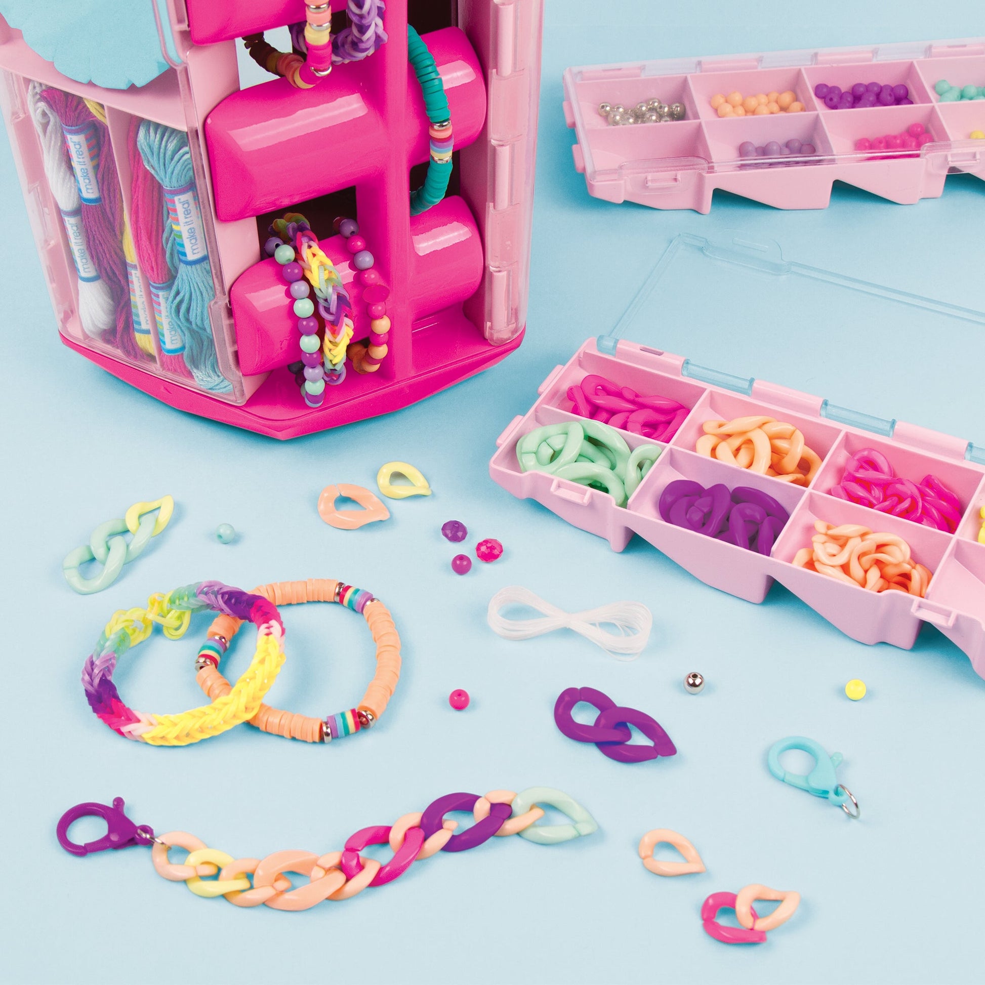 Open pink activity tower with bracelet strings and bead parts on table