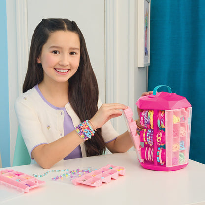 Girl holding colorful bead bracelet in front of pink activity tower