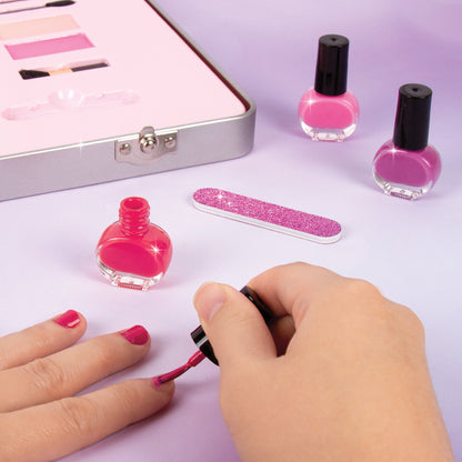Hand applying makeup brush with pink nail polish bottles and glitter nail file