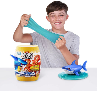 Robo Alive Deep Sea Monster toy shark with turquoise slime, shown beside a small jug