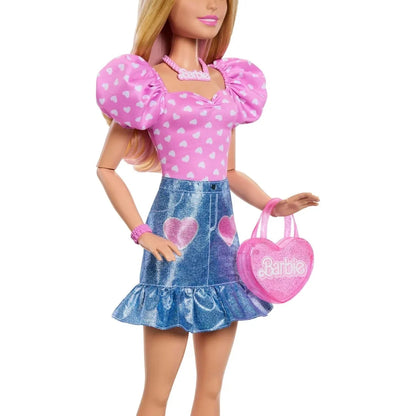Fashion doll in pink heart top and blue denim skirt holding pink Barbie purse