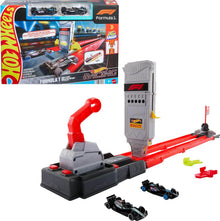 Racing toy car track set with red start gate, red rails, and two black die-cast cars