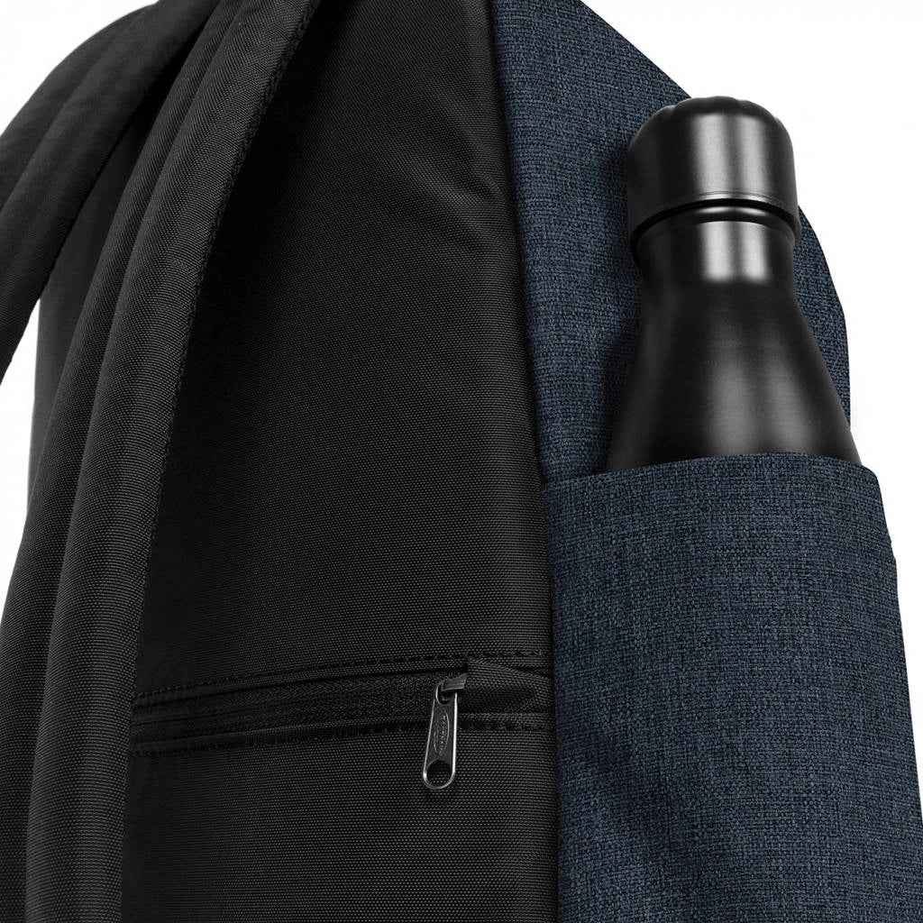 Denim mini backpack side pocket holding a black water bottle