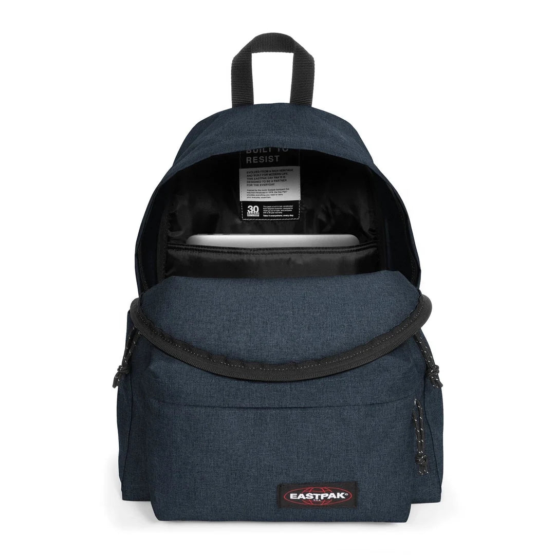 Denim-blue backpack with open top showing inner pocket and logo patch