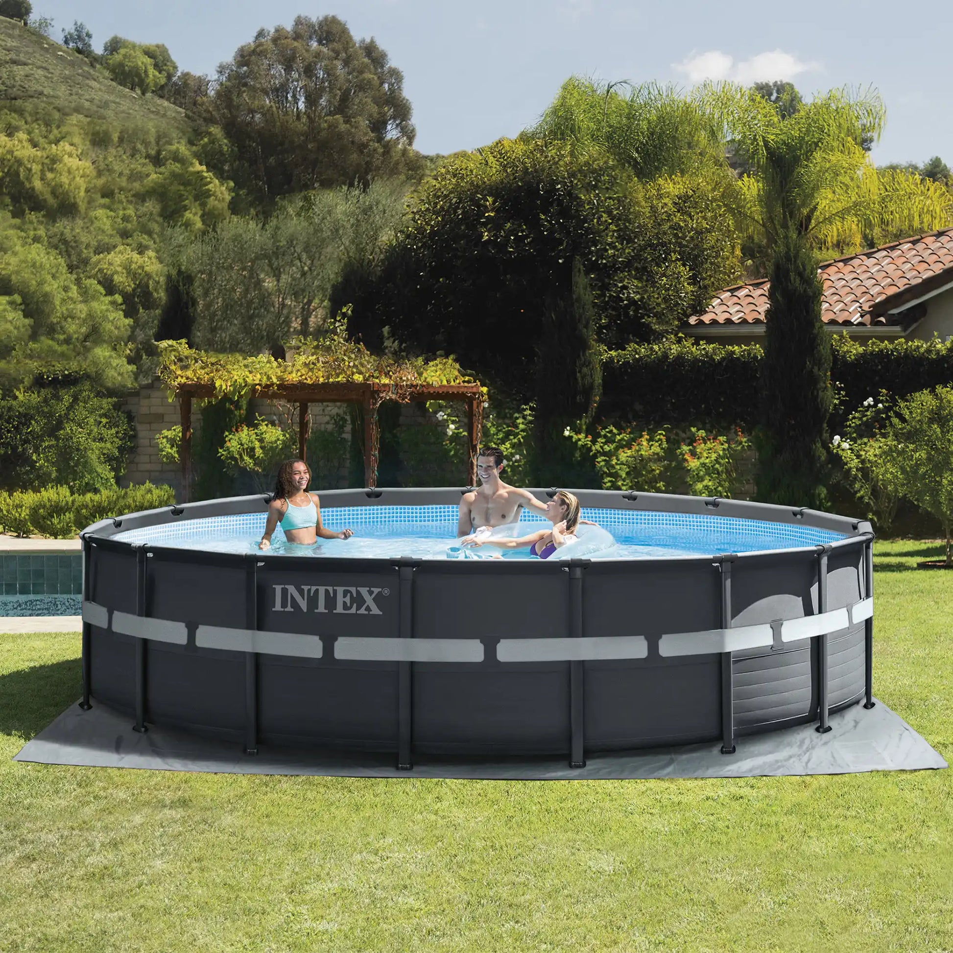 Round INTEX frame pool with blue liner, dark frame, and gray base mat on grass