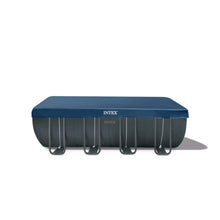 Rectangular above-ground pool set with blue top and black ladder brackets, Intex