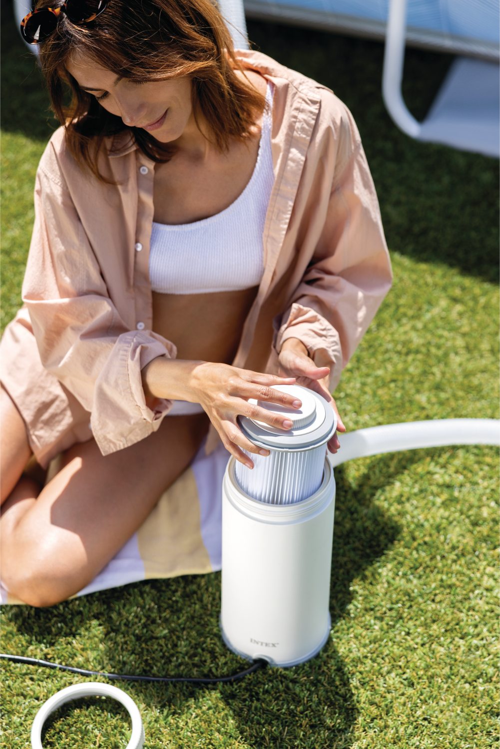 White cartridge filter pump with ribbed hose and power cord attached