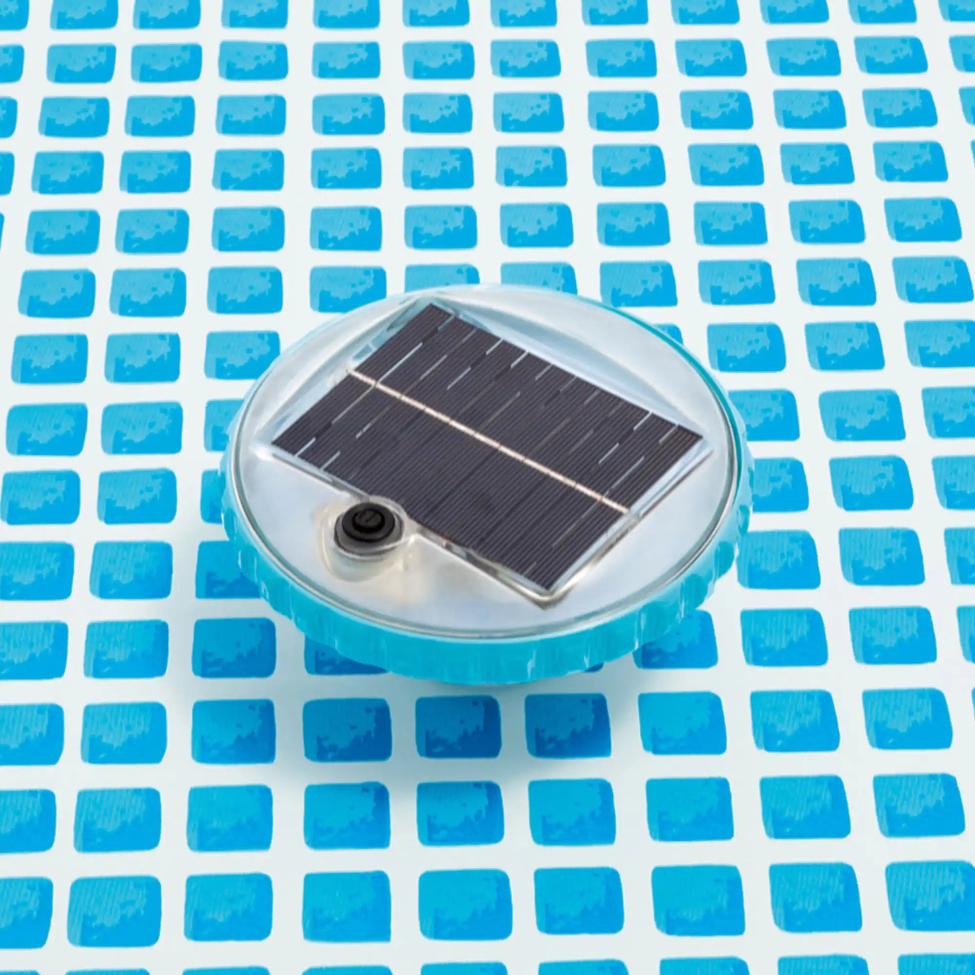 Solar-powered LED floating pool light with black solar panel and gray button detail