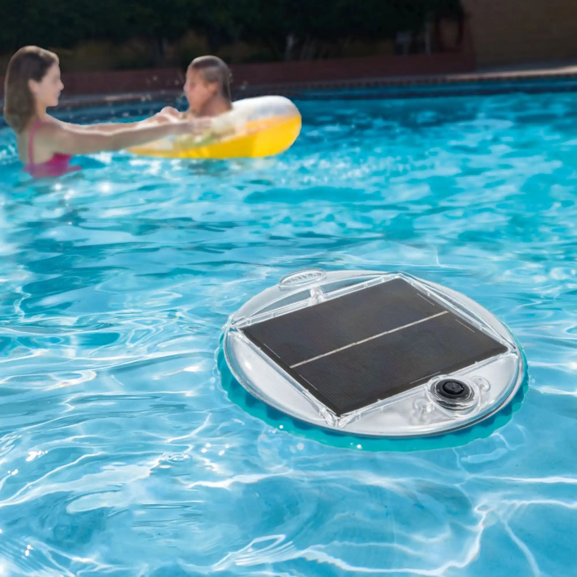 Solar-powered LED floating pool light on water, clear top and black solar panel