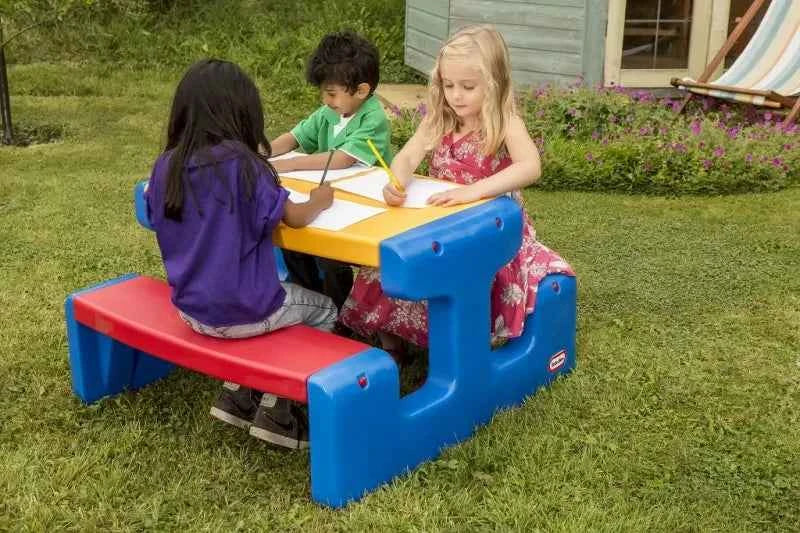 Children’s primary picnic table outdoors with blue frame, yellow top, and red bench