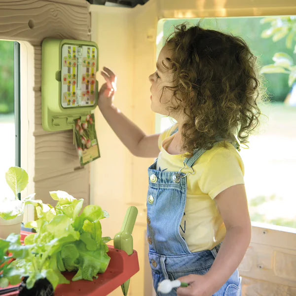 Playhouse interior wall with green panel door and outdoor play accessories