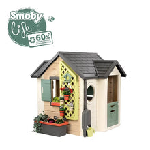 Garden playhouse with green lattice door, gray roof, and arched front window