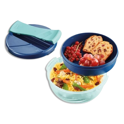 Open large lunch bowl with mint base and dark blue divider, filled with salad, bread, fruit.