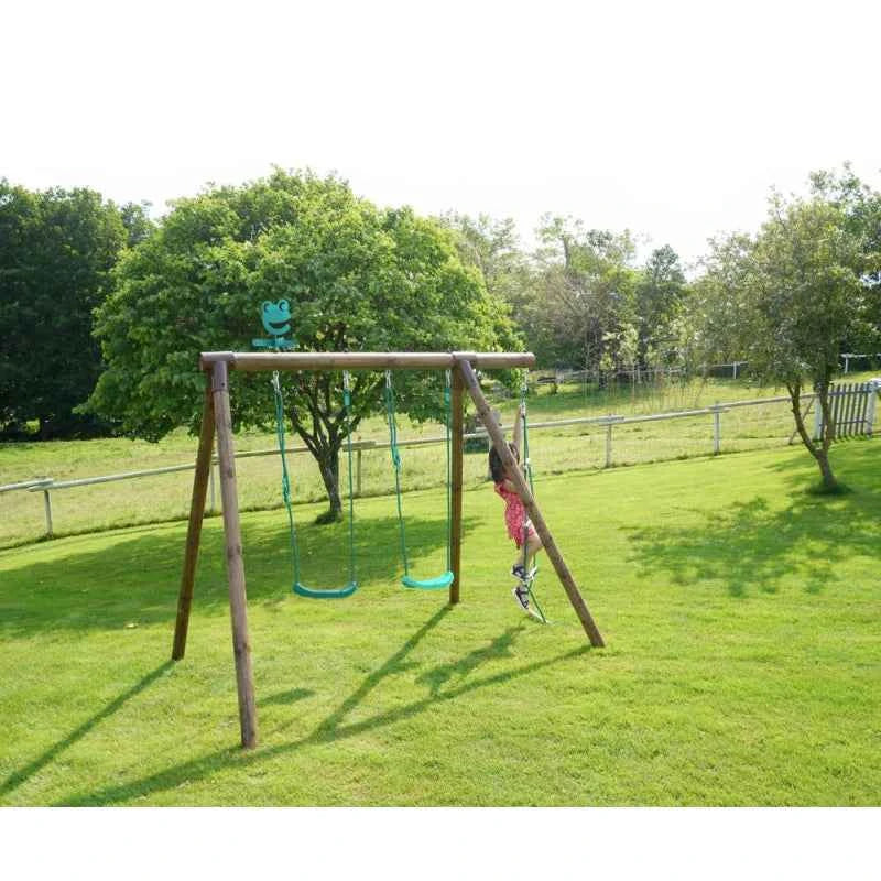 Outdoor wooden swing set with multiple swings and a ladder, set on a lawn.