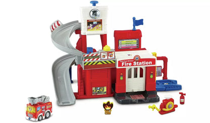 Red fire station toy with slide, ladder tower, and small vehicle accessories