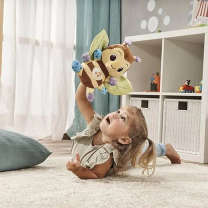 Plush bee toy with fabric wings being played with by a baby