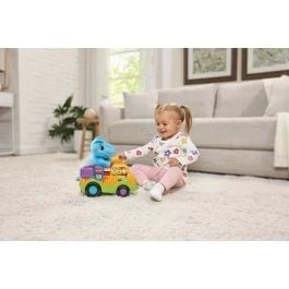 Dino Rescue toy truck with blue dinosaur figure, rolling wheels, and light-up details