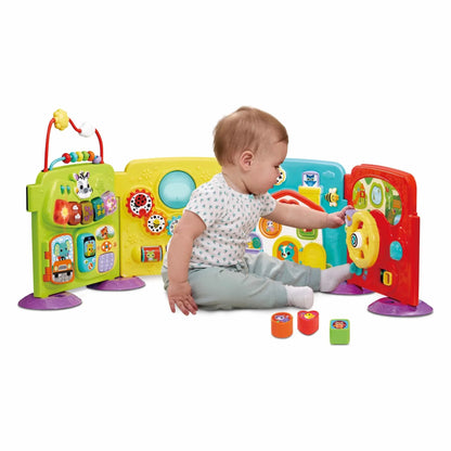 Toddler playing with colorful VTech learning activity play centre with buttons