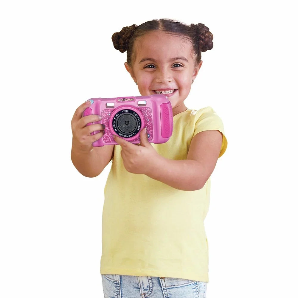 Child holding a pink Kids digital camera with lens and wrist strap