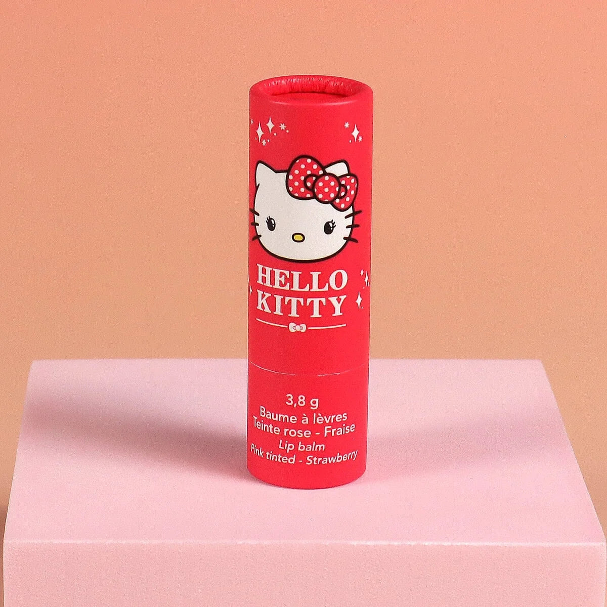 Red Hello Kitty tinted lip balm tube labeled 3.8 g, strawberry pink tint