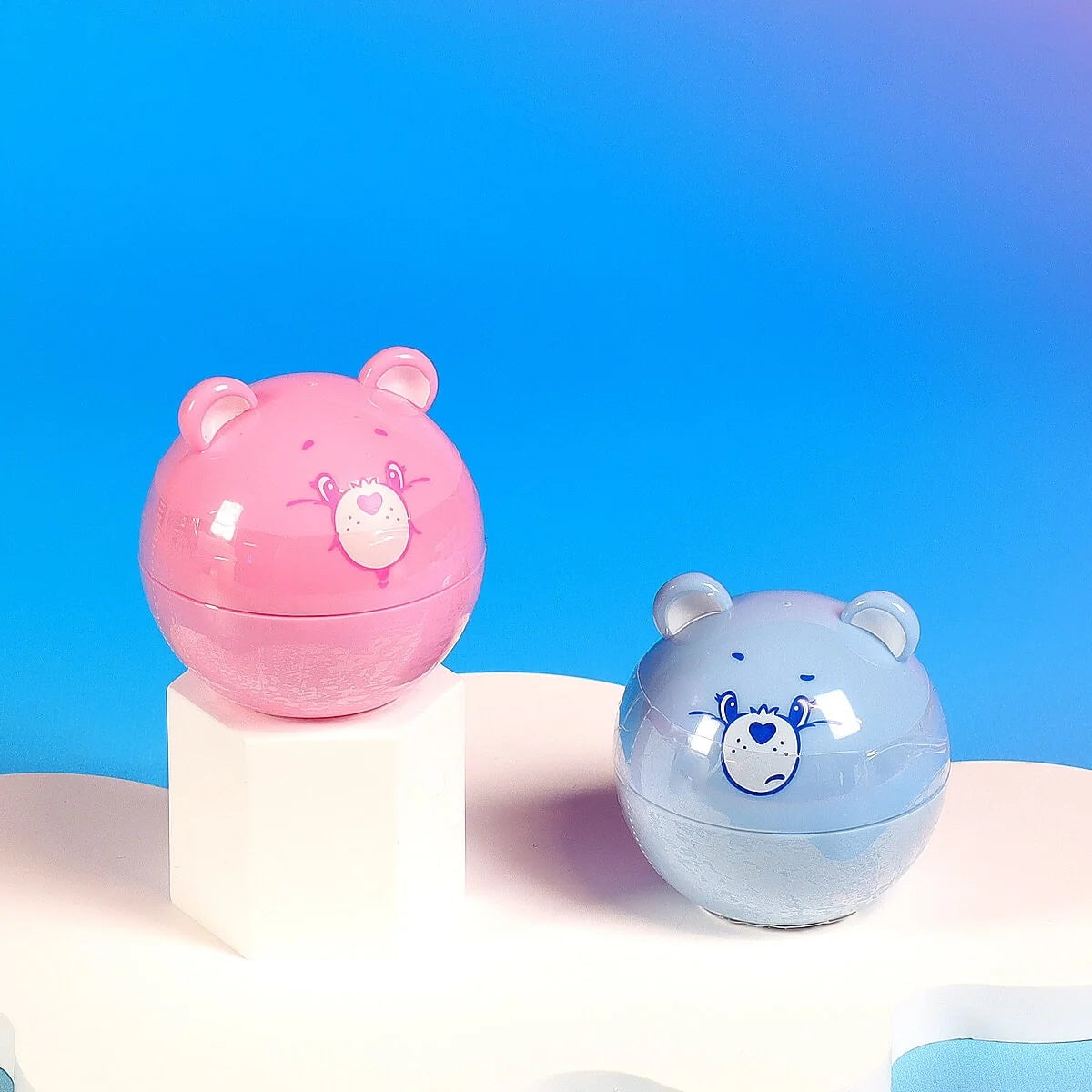 Bear-shaped lip balm containers, glossy pink and blue with cartoon bear faces