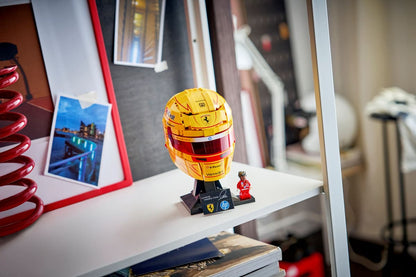 Yellow racing helmet on black stand on a shelf with a small racing figure