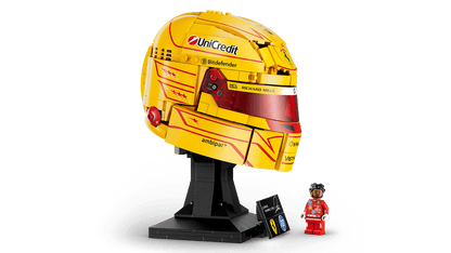 Three-quarter view of yellow racing helmet model on black stand with small figure