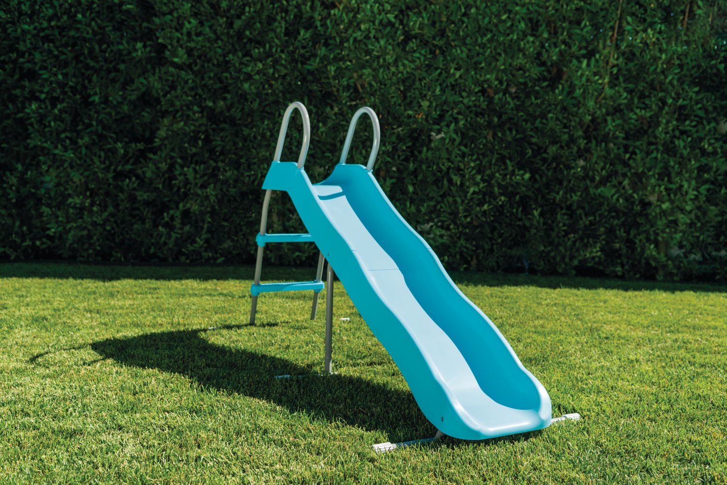 Outdoor freestanding slide with blue slide chute, white side rails, and ladder