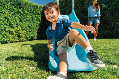 Blue freestanding slide with curved chute and handholds, shown with a child