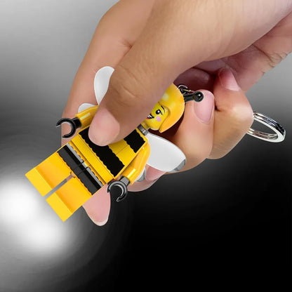 Bee keychain light in yellow with black accents, white wings, and metal key ring