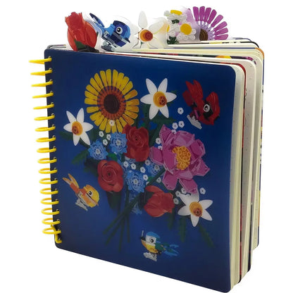 Blue spiral-bound notebook with colorful flowers, birds, and butterfly on front cover