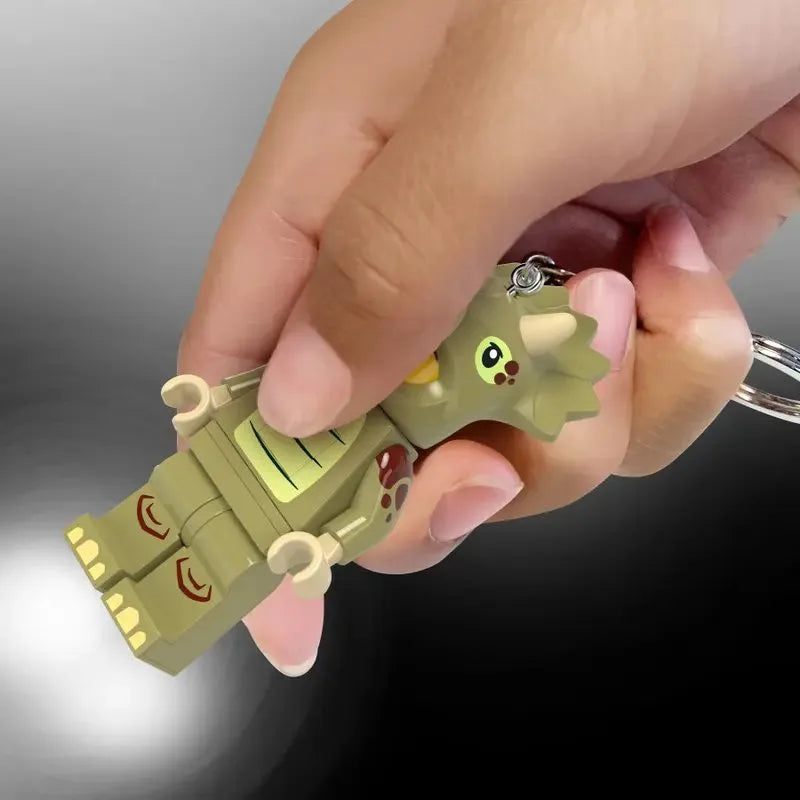 Light green triceratops LED key chain fan held in hand, small costume