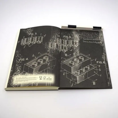 Black notebook with gel pen, blueprint-style circuit diagrams on cover