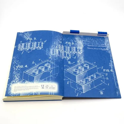 Blue notebook open flat with diagrams on pages and pen clipped on top