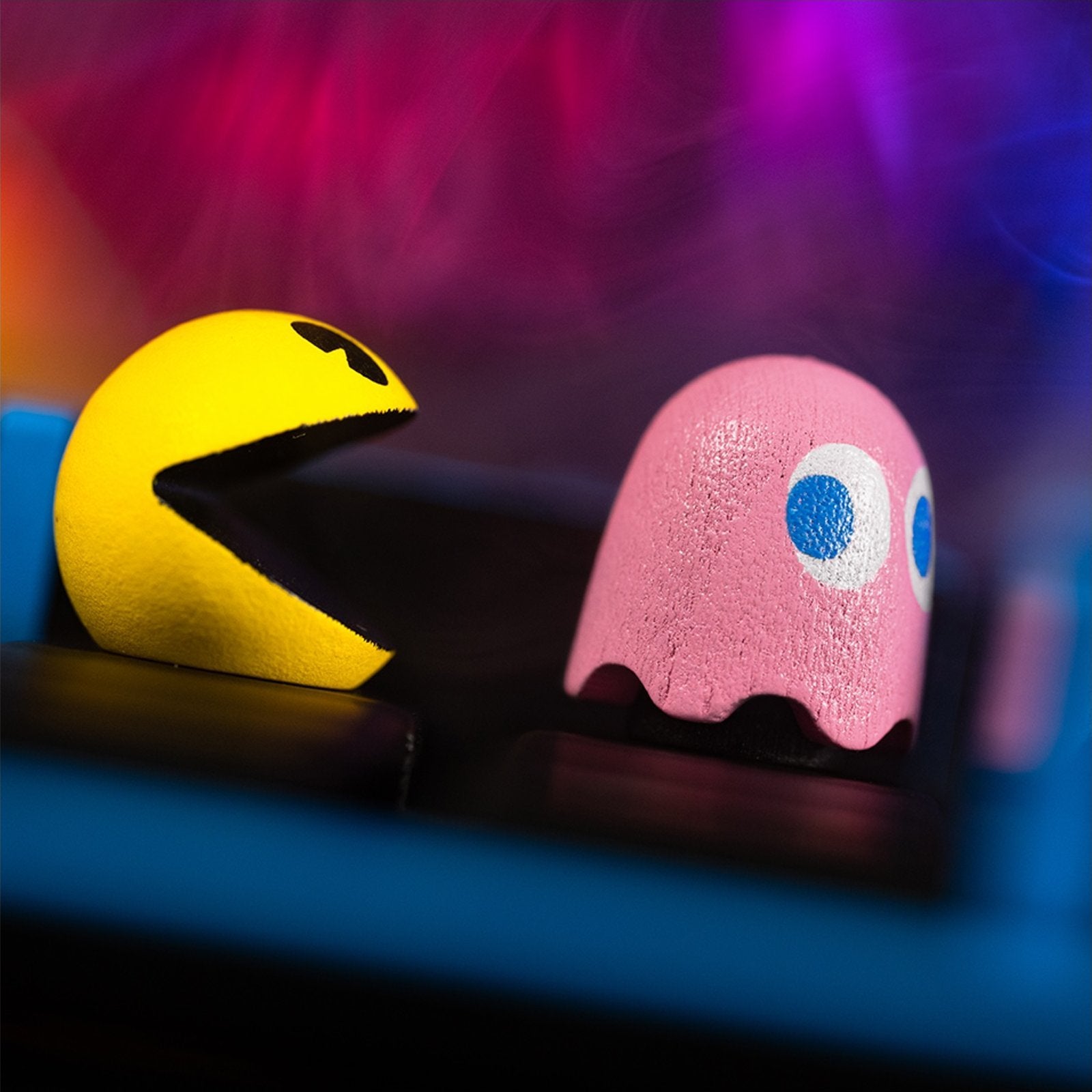 Pac-Man and ghost character pieces on a board, including pink and yellow faces