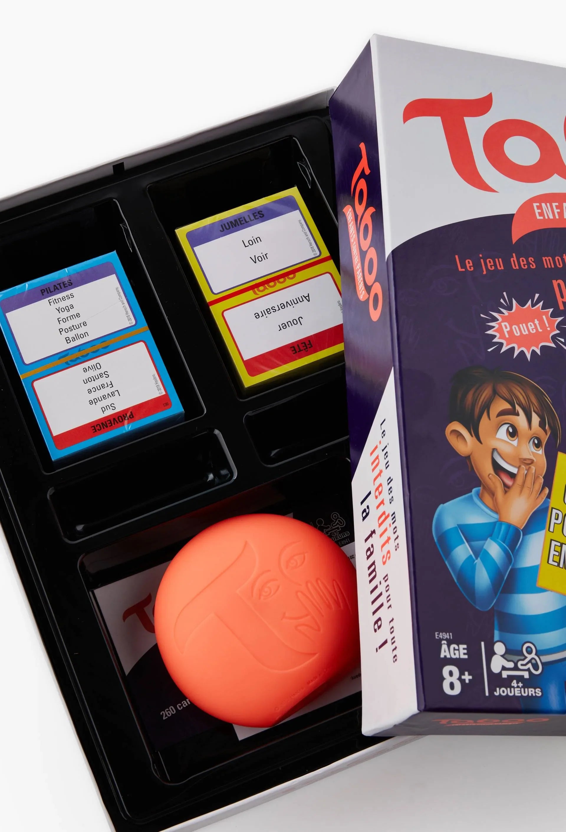 Taboo-style family card game in open box with cards and orange buzzer ball