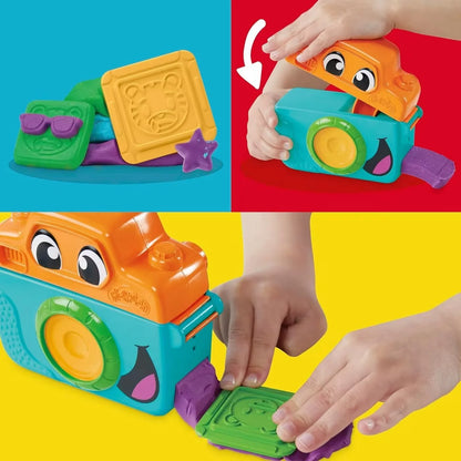Hands pressing clay with the orange toy photo camera and green/purple molds