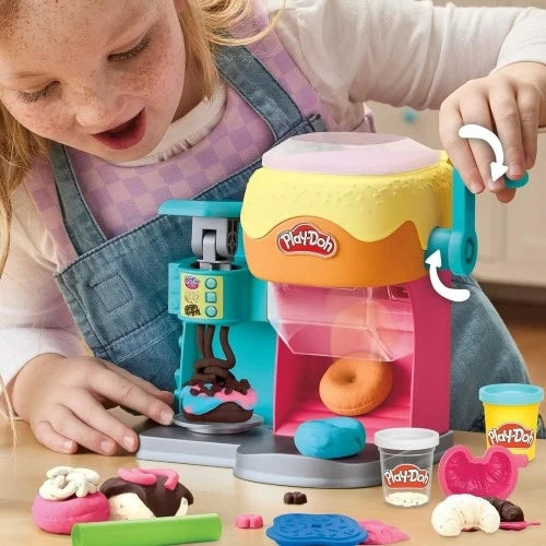 Play-Doh donut drop playset used by a child, teal machine dispensing dough ball