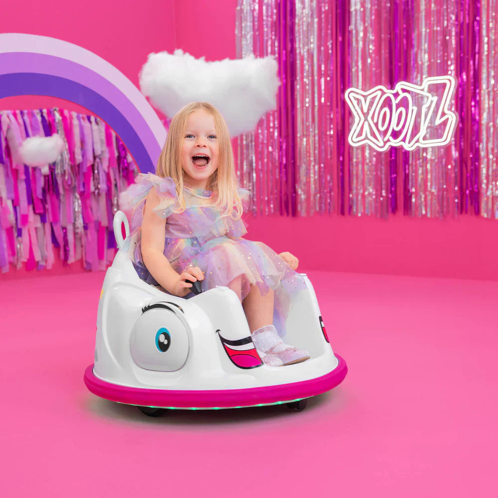 Child in unicorn electric bumper car, white shell with blue eye and pink base