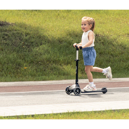 Black sparkling kids scooter with three wheels, ridden by a child outdoors