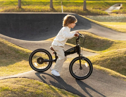 Schwarzes 16-Zoll-Kinderfahrrad mit braunem Sattel und orangefarbenen Lenkergriffen