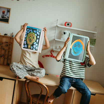Kids holding A4 light drawing tablets, showing colorful drawings