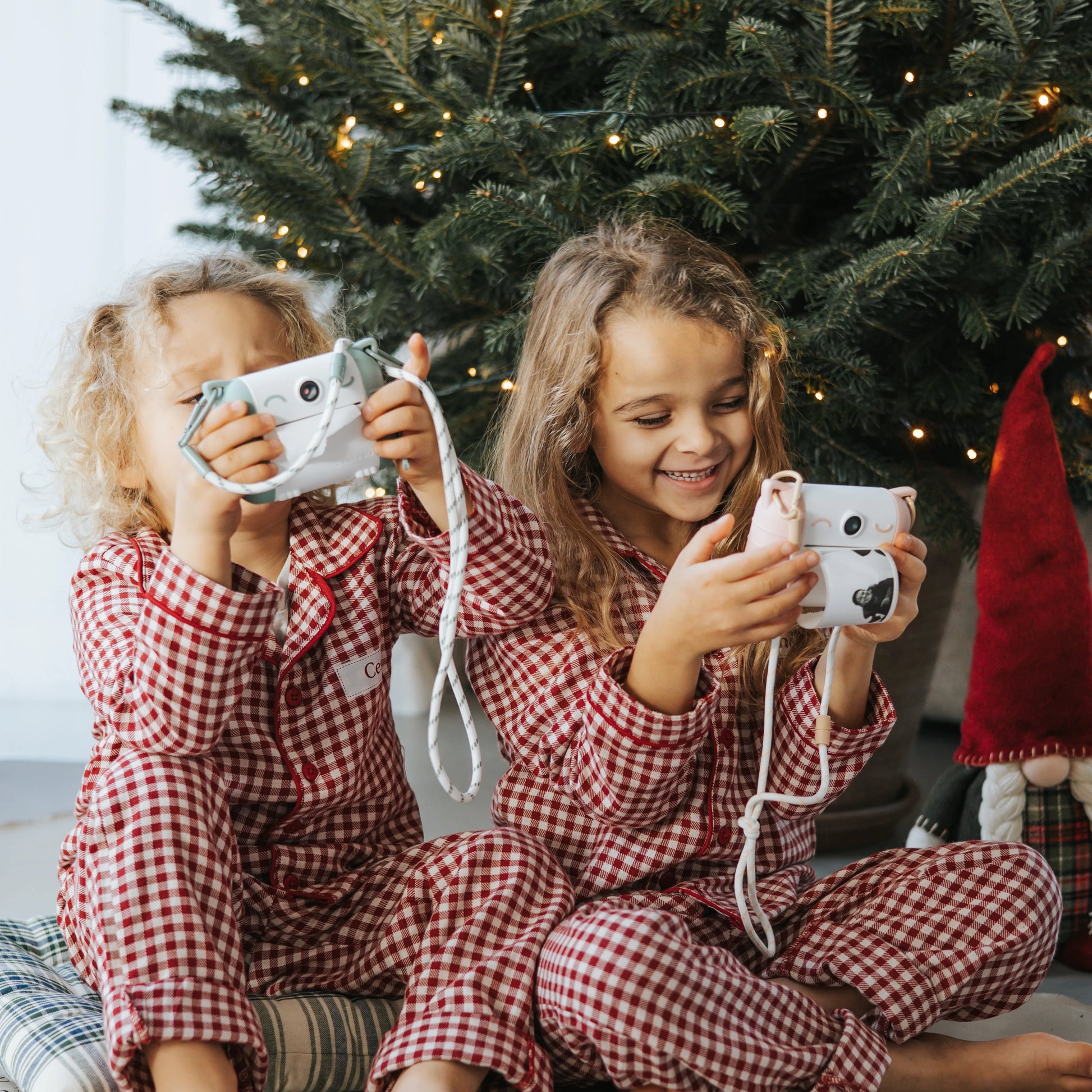 Kids using a mint green and white thermal print camera, aiming the lens outward