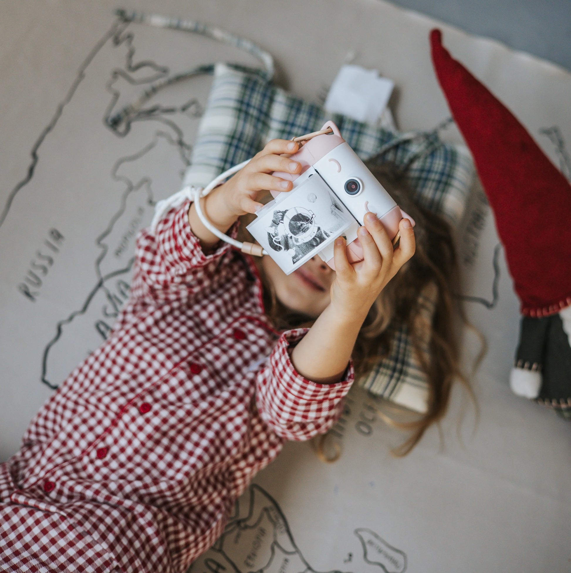 Rose kids thermal print camera held by a child, front photo window visible