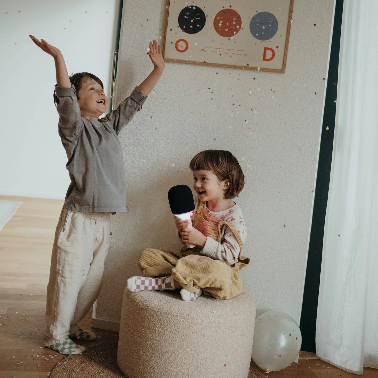 Pink karaoke microphone held by a child, with black foam head