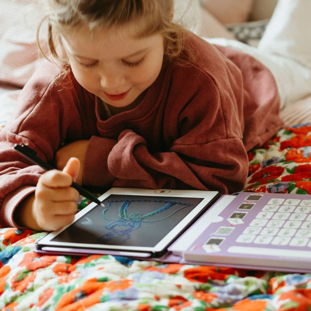 Kidydraw mini drawing pad in use: child draws on purple-edged screen with stylus