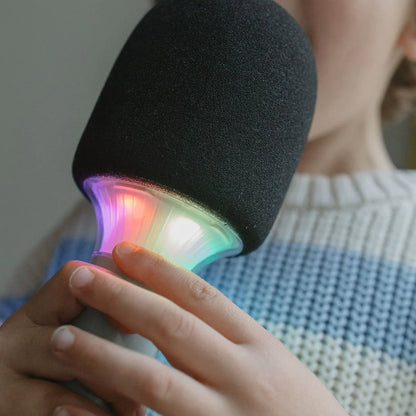 Close-up of Kidymic karaoke microphone with dark foam head and multicolor glowing LED ring